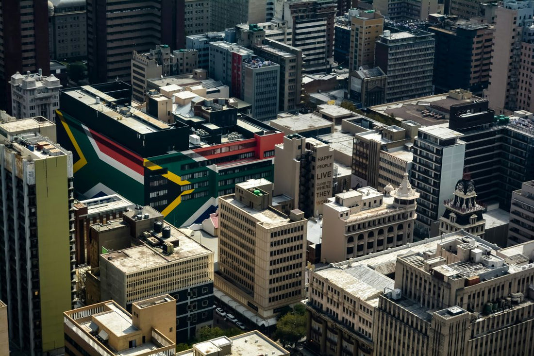 Aerial view of Johannesburg buildings featuring a large South African flag mural.