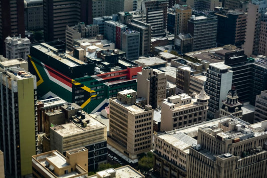 Aerial view of Johannesburg buildings featuring a large South African flag mural.
