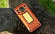 Orange Oukitel WP500 Ultra rugged 5G smartphone resting on a tree branch